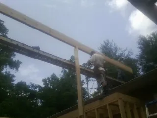 Carpenter setting a ridge beam over a new addition frame — Ice Dam Removal by Roofing Brothers in Loma Linda