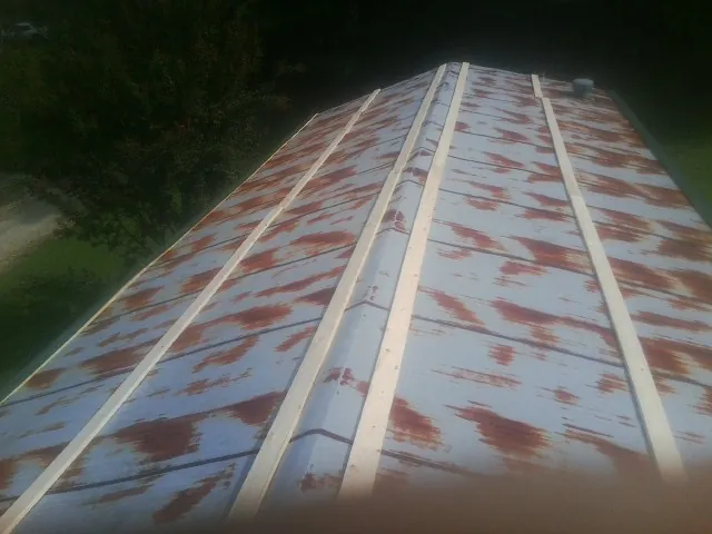 Rusted metal roof panels with new wood purlins before replacement — Storm Damage Roof Repair in Loma Linda by Roofing Brothers
