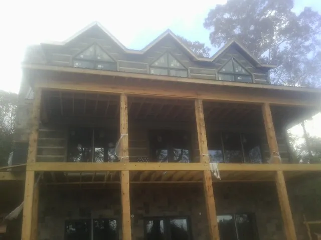 Dormers and porch framing on a large log home under construction — Roof Coating work by our crew in Loma Linda